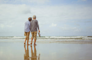 mature couple walking beach