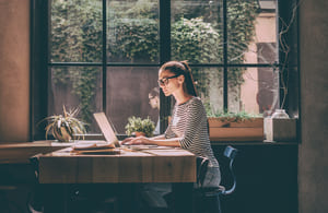lady sitting at table using laptop