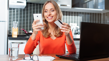 Woman holding credit card and phone